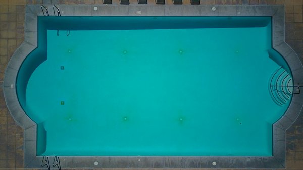 How can you create a relaxing atmosphere around your home swimming pool?